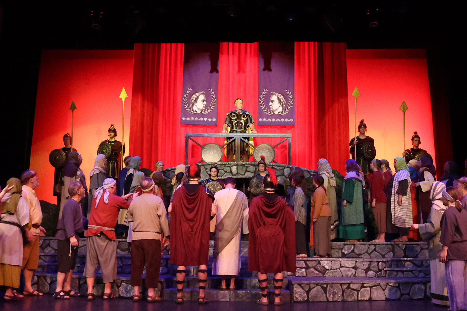 Pilate stands on a raised platform surveying Jesus.